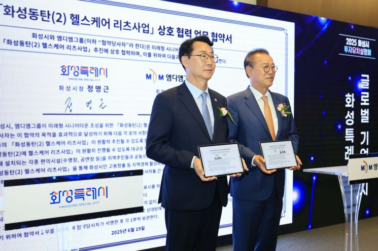 19일 서울 삼성동 코엑스에서 화성시가 개최한 투자유치설명회에서 정명근 화성시장(왼쪽)과 문주현 MDM그룹 회장이 '동탄2 헬스케어 리츠 사업' 추진을 위한 업무협약서를 들어보이고 있다. 화성시 제공
