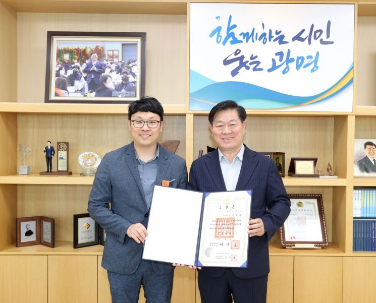 지난달 적극행정 유공 정부포상에서 근정포장을 받은 이현우 광명시 주무관(왼쪽)이 박승원 광명시장과 기념촬영을 하고 있다. 시는 이 주무관의 적극행정 공로를 인정해 19일 특별승진을 결정했다. 광명시 제공