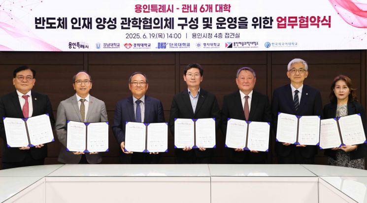 용인시와 관내 6개 대학이 참여해 개최한 '반도체 인재 양성 관학협의체' 업무협약식에서 이상일 용인시장(가운데) 등 참석자들이 협약서를 들어보이고 있다. 용인시 제공