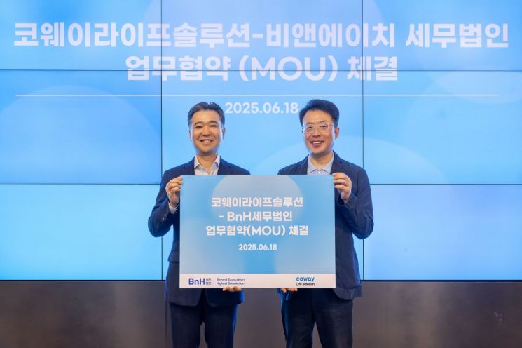 지난 18일 서울 구로구 지타워 코웨이라이프솔루션 본사에서 열린 협약식에서 김명곤 코웨이라이프솔루션 대표이사(오른쪽)와 이명수 BnH세무법인 부대표가 기념 촬영을 하고 있다. 코웨이