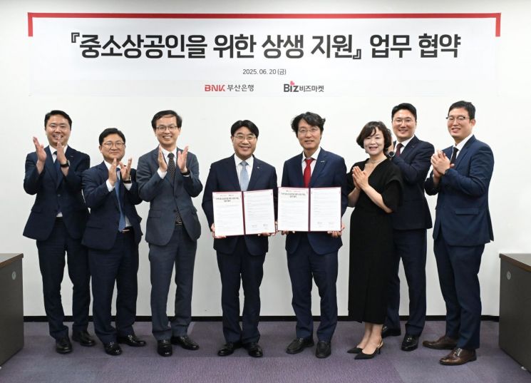 BNK부산은행 방성빈 부산은행장(왼쪽에서 4번째)과 허탁 비즈마켓 대표(왼쪽에서 5번째) 등 관계자들이 중소상공인을 위한 상생 지원 업무 협약을 맺고 있다.