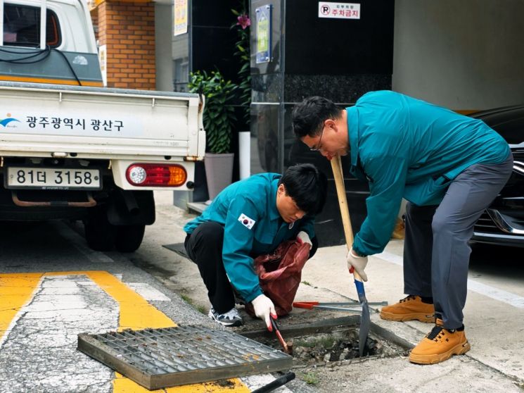 광산구 관계자들이 지난 20일 송정1동에서 장마철을 대비해 빗물받이를 점검하고 있다. 광산구 제공