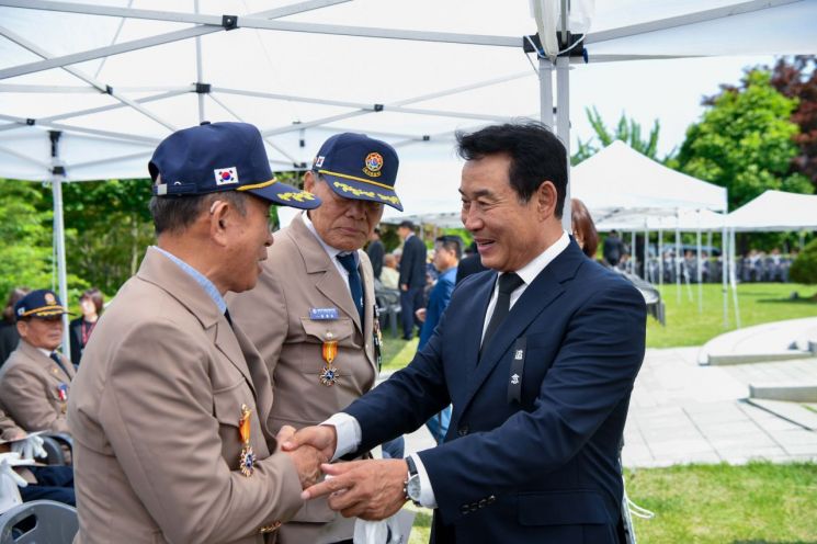 백영현 포천시장이 지난 6일 현충일 추념식에서 나라를 위해 헌신한 국가유공자와 악수를 하고 있다. 포천시 제공