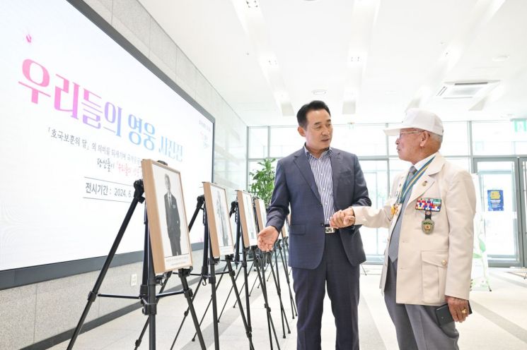 백영현 포천시장이 '우리들의 영웅 사진전'에 참석해 유공자와 이야기를 나누고 있다. 포천시 제공