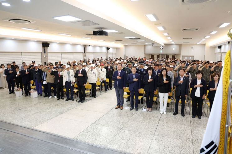 경남 김해시청 대회의실에서 열린 '6·25전쟁 제75주년 기념식' 참석자들이 국기에 대해 경례하고 있다. 김해시 제공