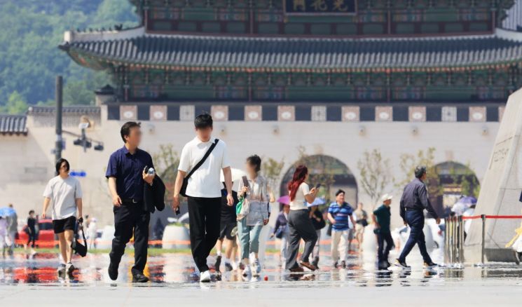 낮 기온이 30도에 육박한 지난달 9일 서울 광화문 광장에서 시민과 관광객들이 뜨거워진 광장 위를 걷고 있다. 연합뉴스