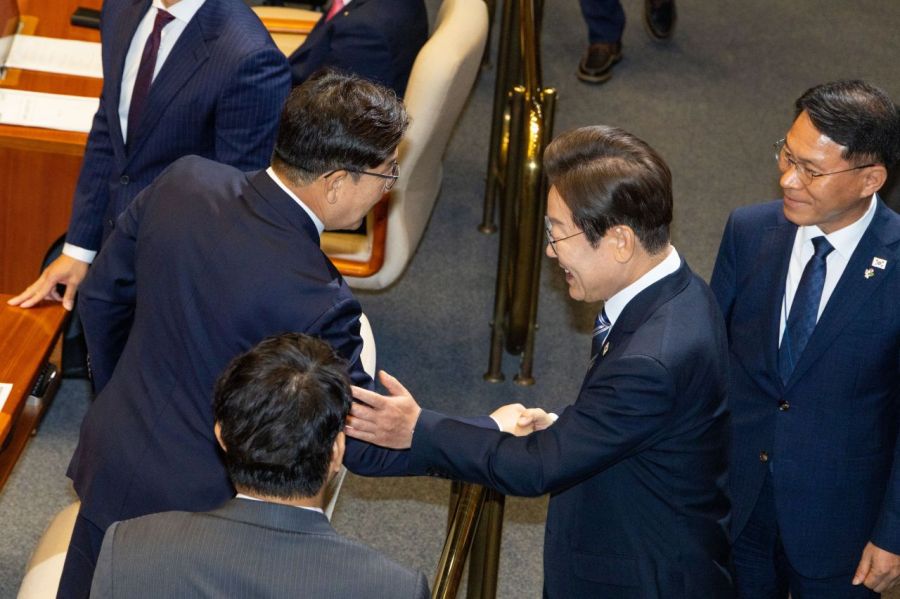 이재명 대통령이 권성동 국민의힘 의원과 악수하며 권 의원의 팔을 툭 치고 있다. 연합뉴스