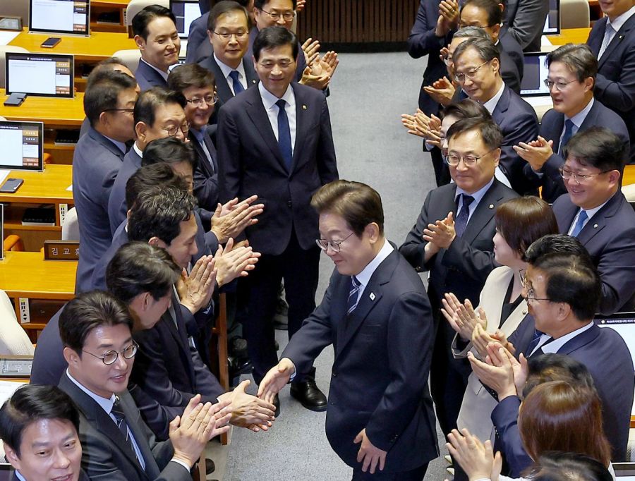 이재명 대통령이 본회의장에 입장해 더불어민주당 의원들의 박수를 받으며 인사하고 있다. 이 대통령은 추가경정예산 시정연설에서 야당의 협조를 요청했다. 연합뉴스