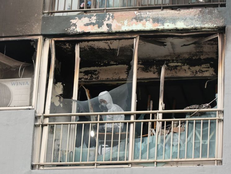 지난 24일 부산 진구의 아파트 화재 현장에서 소방당국과 경찰 등 관계 기관이 합동감식을 벌이고 있다. 연합뉴스