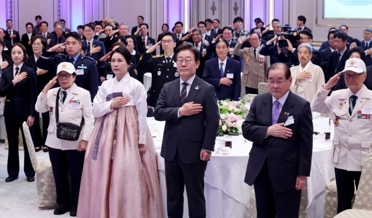 이재명 대통령과 김혜경 여사가 27일 청와대 영빈관에서 열린 '호국 보훈의 달, 대통령의 초대' 행사에서 국기에 경례하고 있다. 연합뉴스