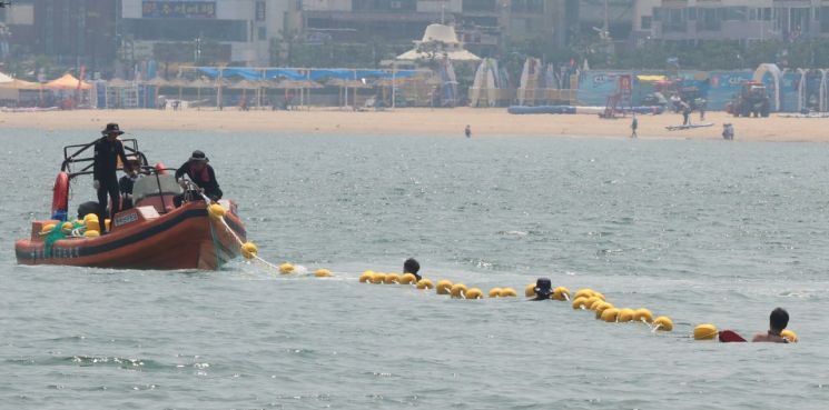 27일 부산 수영구 광안리 해변에서 구청 관계자가 해파리 차단 그물망을 설치하고 있다. 연합뉴스