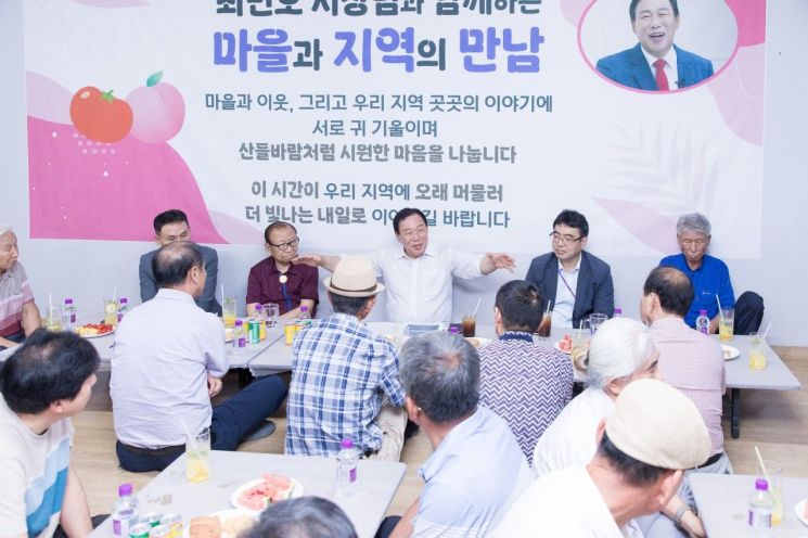 최 시장이 음료수를 앞에 두고 주민들과 즐겁게 대화하고 있다.