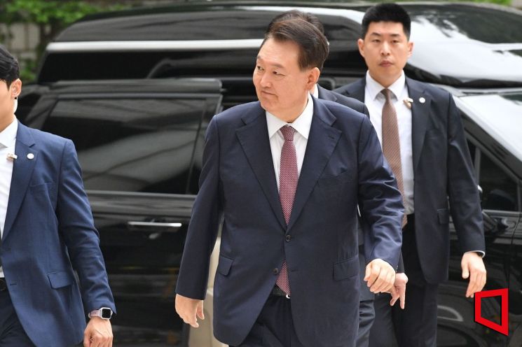 윤석열 전 대통령이 지난 3일 서울 서초구 서울중앙지방법원에서 열린 내란 우두머리 혐의·직권남용 권리행사 방해 혐의 사건 9차 공판에 출석하며 지지자들을 향해 미소를 보이고 있다. 사진공동취재단
