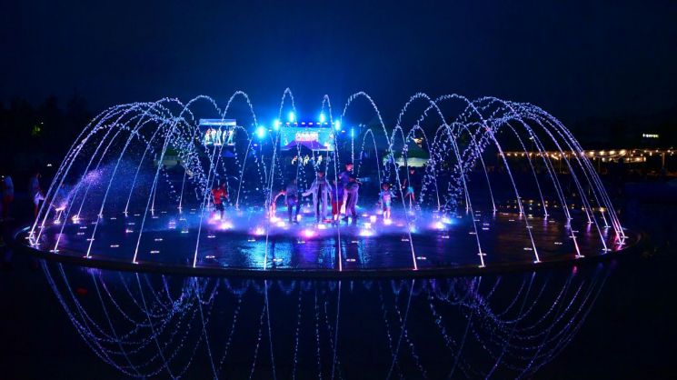 화려한 조명과 음악에 맞춰 물줄기가 연출되는 삼계면 상무평화공원의 음악분수. 여름 밤, 피서객들이 분수 속에서 더위를 식히고 있다. 장성군 제공