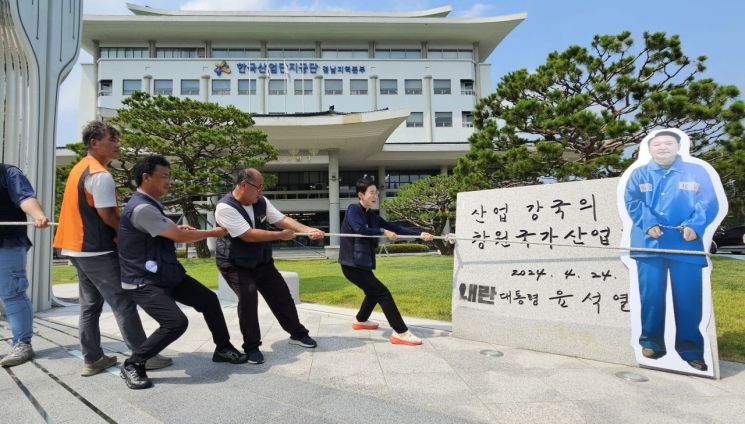 민주노총 경남본부가 한국산업단지공단 경남지역본부 앞마당에 설치된 윤석열 전 대통령 친필 휘호 표지석을 철거하는 퍼포먼스를 펼치고 있다. 이세령 기자
