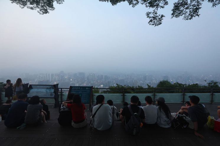 서울 지역에 올해 첫 폭염경보가 발효된 7일 서울 남산을 찾은 시민과 관광객들이 휴식을 취하고 있다. 연합뉴스