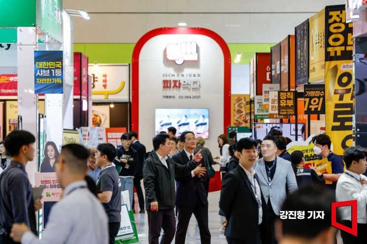2023년 서울 코엑스에서 열린 프랜차이즈 박람회에 참가한 프랜차이즈 업체들의 간판과 광고가 빼곡히 붙어 있다. 강진형 기자
