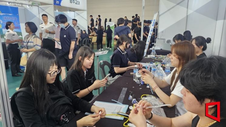 '2025 광양만권진로진학박람회'을 찾은 여학생들이 체험부스 앞에서 키링을 만드는 작업을 하고 있다. 이준경 기자