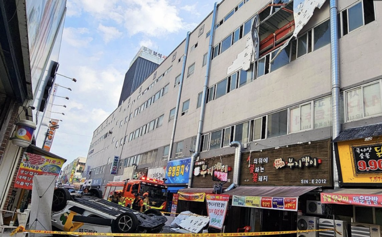 광주 북구 일곡동의 한 주차타워에서 추락한 택시가 건물 앞 도로에 전복돼 있다. 북부소방서, 연합뉴스