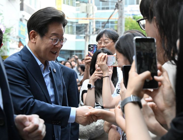 이재명 대통령이 11일 저녁 서울 광화문 인근 한식당 앞에서 시민들과 인사하고 있다. 연합뉴스