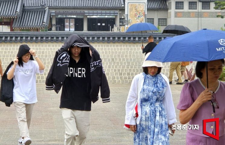 서울 종로 경복궁을 찾은 관광객들이 비를 피해 이동하고 있다. 조용준 기자