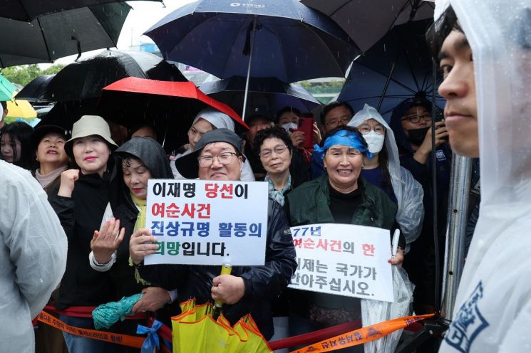 지난 5월 15일 전남 여수시 이순신 광장에서 열린 더불어민주당 이재명 대선후보가 집중 유세에서 지지를 호소하는 가운데 일부 시민들이 여순사건 진상규명을 촉구하고 있다. 연합뉴스