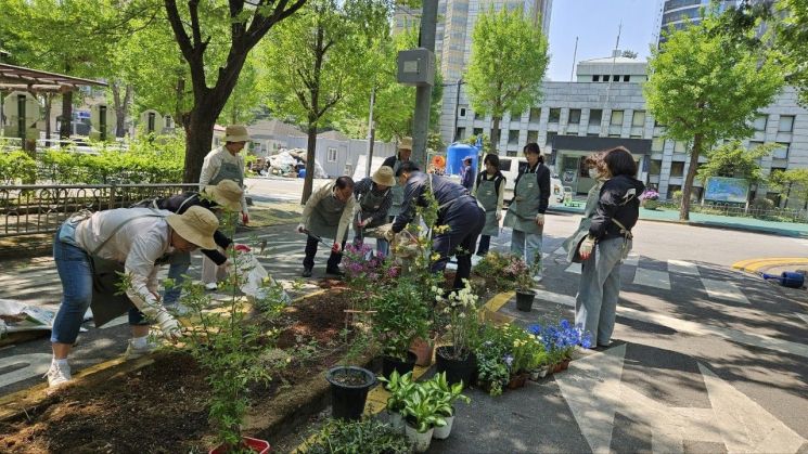 송파구 마을정원사들이 신천근린공원 내 정원을 조성해 나가고 있다. 송파구 제공.