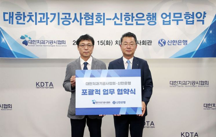 지난 15일 서울시 동대문구 소재 치과기공사회관에서 진행한 '대한치과기공사협회-신한은행' 업무협약식에서 김재민 신한은행 영업추진1그룹장(오른쪽)과 김정민 대한치과기공사협회장이 기념촬영하는 모습. 신한은행 제공.