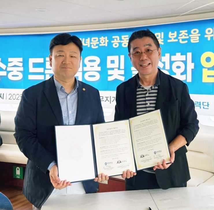 업무협약서 들고 기념 촬영하는 양종훈 이사장(사진 오른쪽)과 이근호 단장. 상명대학교
