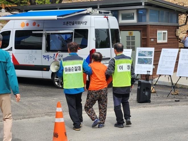 주민을 대피시키는 마을 순찰대. 연합뉴스