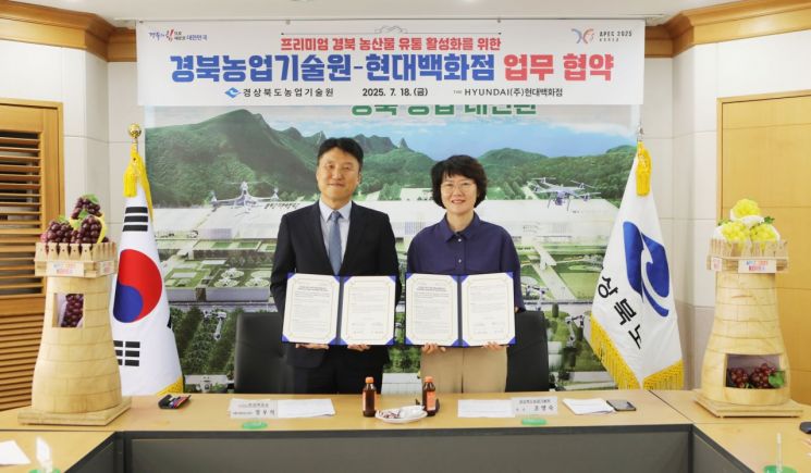 조영숙 경북농업기술원장(오른쪽)과 장우석 현대백화점 식품사업부장이 업무협약을 체결한 뒤 협약서를 들고 기념촬영을 하고 있다.