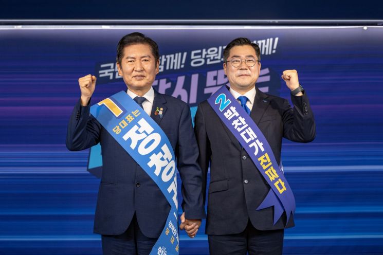 더불어민주당 대표 선거에 출마한 정청래(왼쪽)·박찬대 후보가 지난 19일 서울 여의도 당사에서 열린 합동연설회에서 함께 주먹을 쥐며 인사하고 있다. 연합뉴스