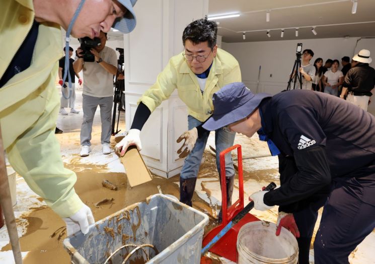 더불어민주당 박찬대 당 대표 후보가 21일 광주 수해 피해 현장인 서구의 한 가구백화점을 찾아 복구 작업하고 있다. 연합뉴스