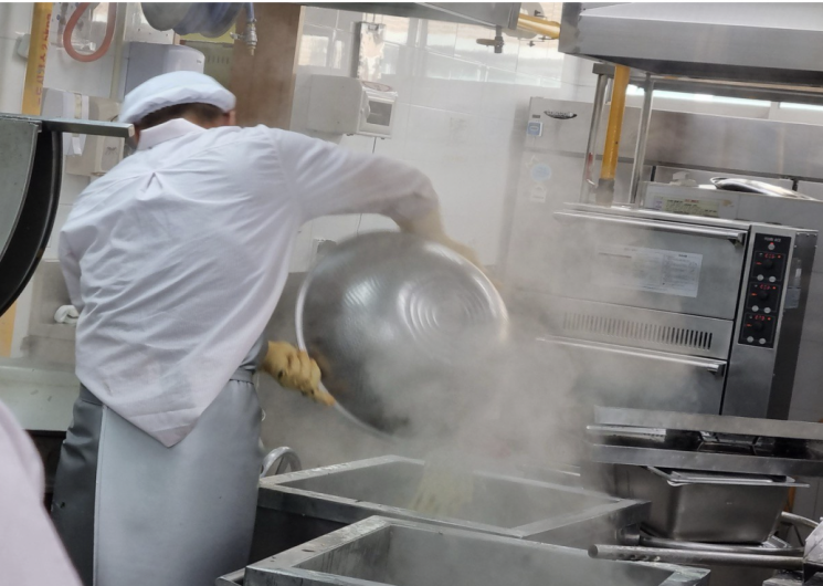 광주의 한 학교 급식실에서 조리 노동자가 뜨거운 증기가 피어오르는 조리통 앞에서 작업하고 있다. 학교비정규직노조 제공