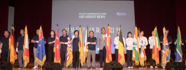 강기정 광주시장이 22일 오후 시청 대회의실에서 열린 '광주 2025 세계양궁선수권대회 시민 서포터즈 발대식'에 참석해 광주시양궁선수단과 함께 태극기 및 대회 홍보기, 참여국가 국기 등을 들고 입장한 후 참석자들과 함께 기념촬영을 하고 있다. 광주시 제공