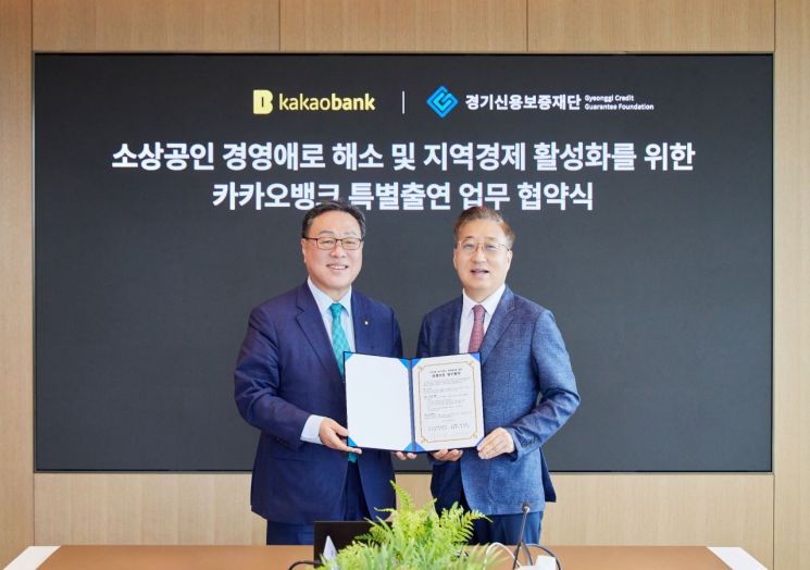 ▲ 윤호영 카카오뱅크 대표이사(오른쪽)와 경기신용보증재단 시석중 이사장(왼쪽)이 22일 경기도 성남시 카카오뱅크 판교 오피스에서 진행된 '경기도 상생보증 업무협약식'에 참석해 기념촬영을 하고 있다. 카카오뱅크 제공.