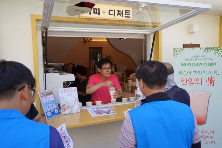 김효명 세종신용보증재당 이사장이 건설노동자에게 복숭아 음료를 건네며 응원의 메세지를 전달하고 있다.