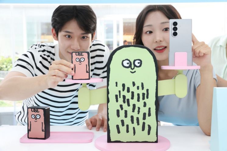 서울 코엑스 'The Galaxy UNFOLDERS' 체험존 방문객들이 아티스트 장 줄리앙의 캐릭터를 활용한 무게 측정 키트로 갤럭시Z 폴드7의 무게를 재는 모습. 삼성전자 제공