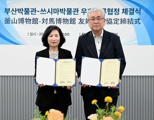 정은우 부산박물관장(왼쪽)과 마치다 카즈토 쓰시마박물관장이 서명한 협정서를 보이고 있다.