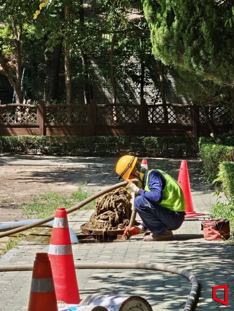 정화조 청소 노동자가 서울 중구의 한 아파트에서 분뇨 정화조 청소 호스를 들고 있다. 박승욱 기자