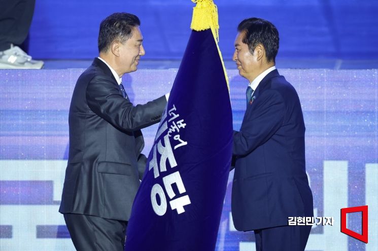 정청래 더불어민주당 신임 당대표가 2일 경기 고양시 킨텍스에서 열린 제2차 임시전국당원대회에서 김병기 원내대표로 부터 당기를 이양받고 있다. 2025.8.2 김현민 기자