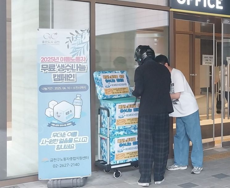 이동노동자가 ‘2025년 이동노동자 생수나눔 캠페인’의 일환으로 비치된 생수를 꺼내가고 있다. 금천구 제공.