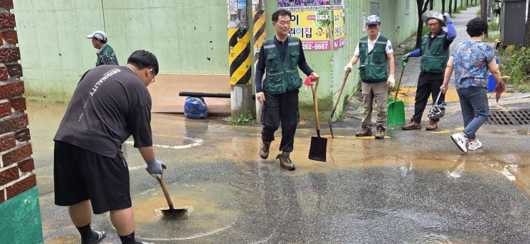 4일 오전 광주 북구 문흥동성당 일대에서 기간제 근로자들이 빗물과 흙을 쓸어내고 있다. 민찬기 기자