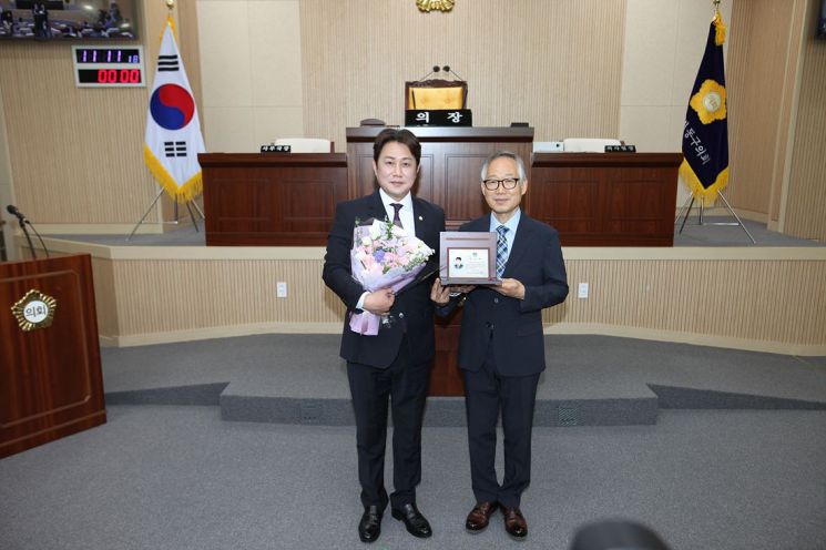 이진욱 대구 동구의원(왼쪽)이 이중구 대구자치경찰위원장한테 감사패와 꽃다발을 받고 기념촬영을 하고 있다.