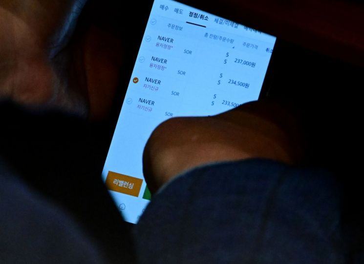 국회 법제사법위원회 위원장을 맡고 있는 이춘석 더불어민주당 의원이 4일 서울 여의도 국회에서 열린 본회의에서 타인 명의로 개설된 주식 계좌를 확인하고 있다. 더팩트 제공