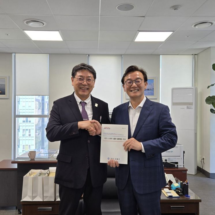 홍태용 경남 김해시장(왼쪽)이 전재수 해양수산부 장관에게 국가 스마트 물류플랫폼 조성사업의 전방위적 지원을 요청하는 건의서를 전달하고 있다. 김해시 제공