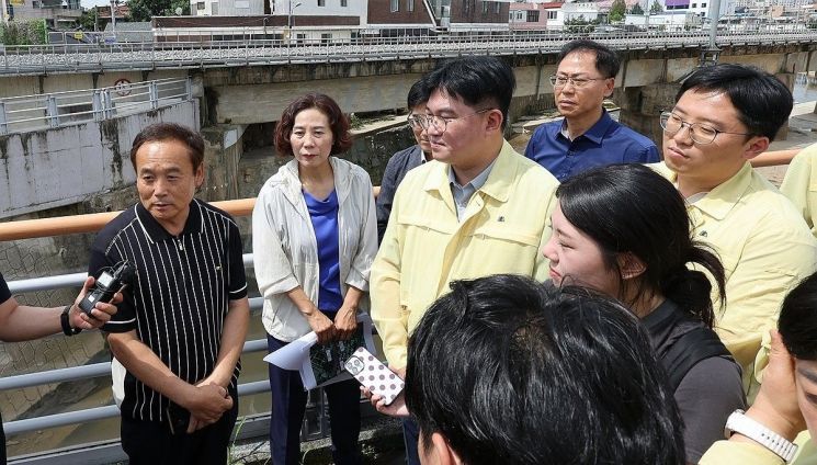 8일 오전 박창근 국정기획위원회 재난안전소위원장이 지난 극한호우로 침수 피해를 본 광주 북구 신안교 현장을 둘러본 뒤 설명하고 있다. 연합뉴스