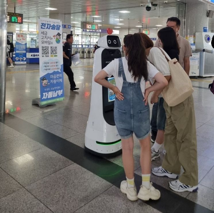 시민들이 지난 8일 의정부역 대합실에서 열린 인공지능 로봇 '세정의'와 함께 이색적인 지방세 홍보 행사에서 관심을 보이고 있다. 의정부시 제공