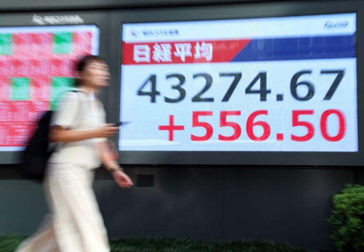 닛케이지수 현황판 지나가는 여성. 연합뉴스