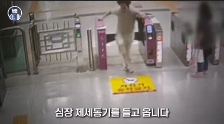지난달 24일 서울 중랑경찰서 정희목 경사가 인근 지하철 역으로 뛰어가 심장 제세동기를 들고 현장으로 돌아가고 있다. 유튜브 채널 '서울경찰' 캡처